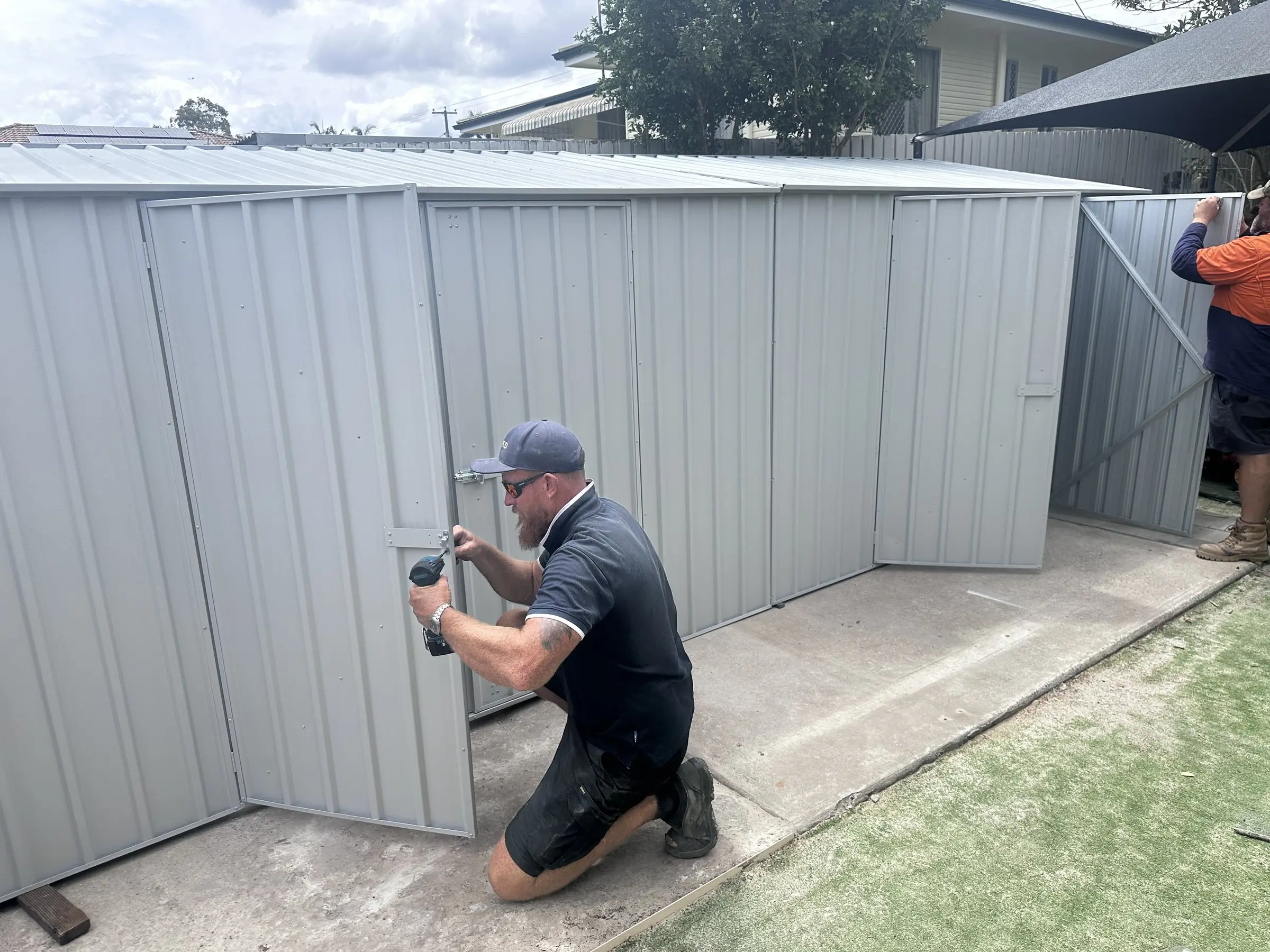 Fixed tradesperson installing a garden shed at a childcare centre
