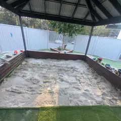 Sandpit top-up under a shade structure at a childcare centre